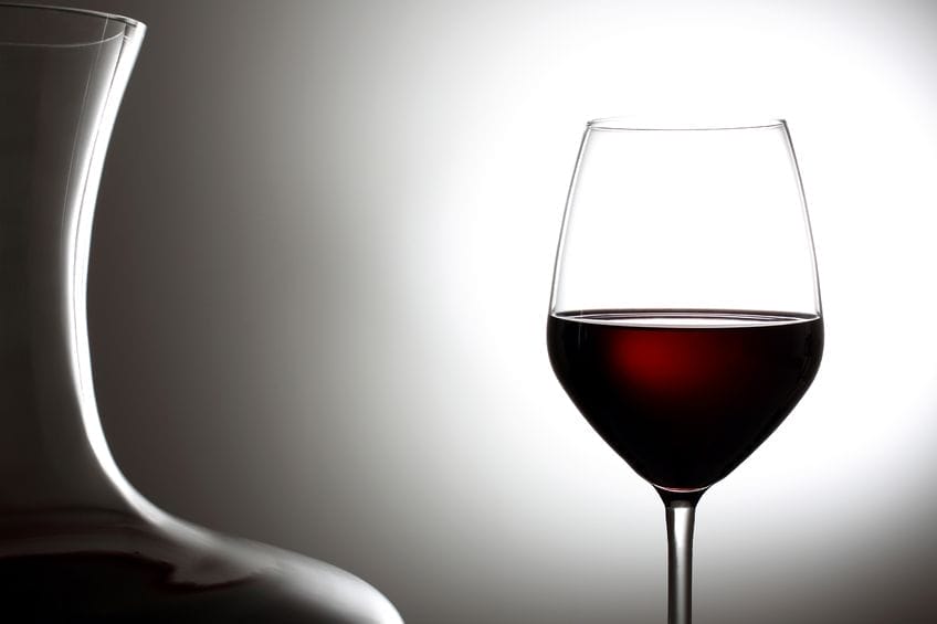 21856308 - red wine in a glass gray background